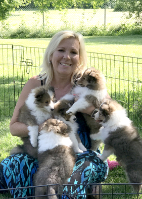 Yvonne playing with puppies in the yard